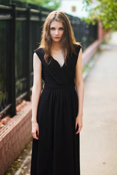 黒のドレスを着た若い美しい女性鋼柵を背景にしたアウトドアファッショナブルな写真夏の夜 きれいな肌のモデル — ストック写真