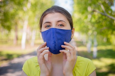 Portrait of a pensive woman in a blue mask on her face. clipart