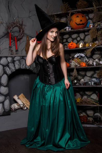 黒のコルセット 緑のスカートと黒の帽子の美しい 若い女性 ハロウィーンの魔女のイメージ きれいな肌をしたモデル — ストック写真