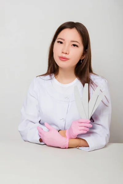 Portrait Woman Master Nails White Coat Gloves Sitting Table White — Stock Photo, Image