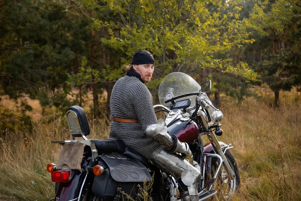 Motocyklista Średniowiecznej Zbroi Rycerskiej Siedzi Motocyklu Tle Lasu — Zdjęcie stockowe