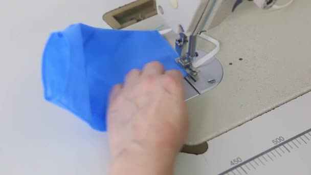 在缝纫机上分阶段用蓝色面料缝制医用口罩 关闭工业缝纫机制造接缝 大肠病毒大流行期间医疗面罩不足的概念 — 图库视频影像