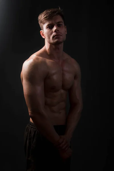 Muskulöser Bodybuilder Posiert Mit Nacktem Oberkörper Auf Schwarzem Hintergrund Dunkeln — Stockfoto