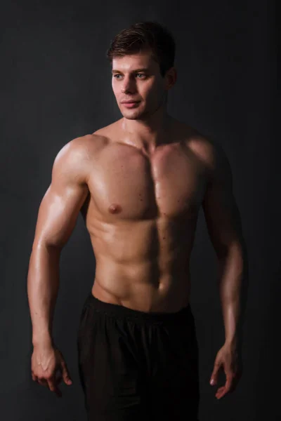 黒の背景に裸体でポーズをとる筋肉のボディビルダー セクシー男 — ストック写真