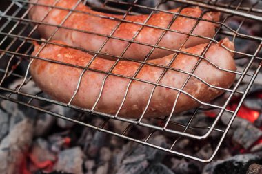 Izgaradaki sosisler açık havada kömürde kızartılıyor..