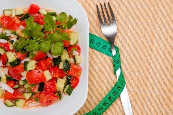西红柿和洋葱沙拉旁边的叉子和一公分 在木架上的白盘上撒满葵花籽油 适当营养的概念 减肥的饮食 — 图库照片