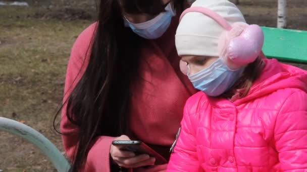 Молодые Мать Дочь Теплой Одежде Защитных Масках Держат Руках Смартфон — стоковое видео