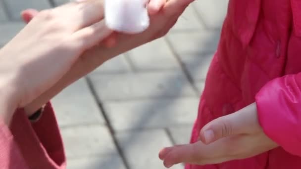 一位站在膝盖上的妇女在公园里散步时 用湿湿的擦擦着小孩的手 — 图库视频影像
