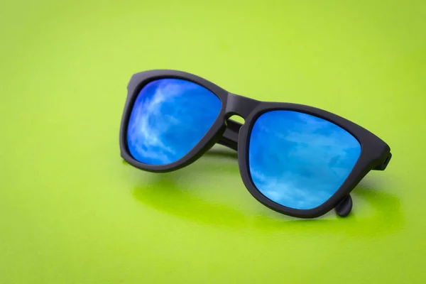 Image of modern fashionable sunglasses on green background, Glasses.