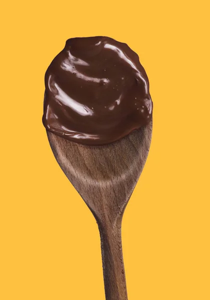 融化的黑巧克力木勺被隔离在黄色背景上 — 图库照片