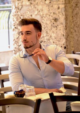 Masada oturan caffee bar restoranda açık genç adam.