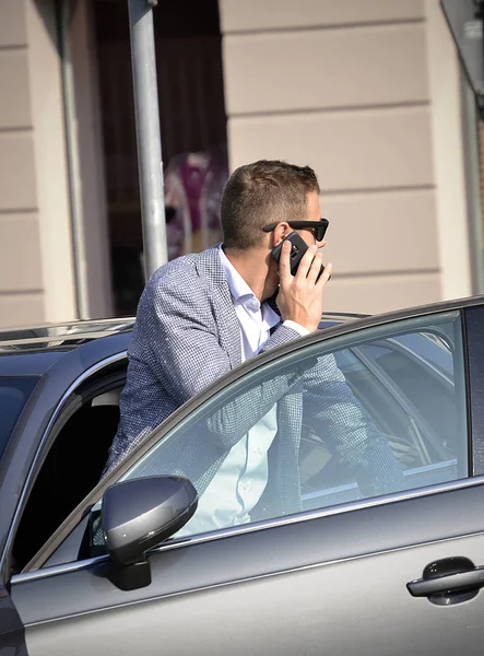 Telephne に車から出てくる若い男 — ストック写真