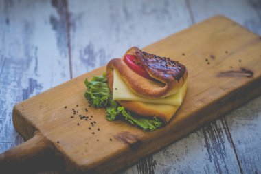 Peynir, otlar ve domates tonda sert ahşap board.photo ve bir skeç ile sandviç