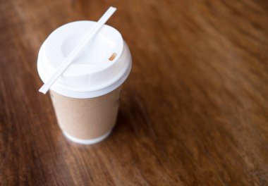 Bir fincan kahve ahşap masa arka plan üzerinde kapatın