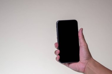 Yaklaş. Akıllı telefon tutan adam sarı arkaplanda siyah ekran izole edilmiş.