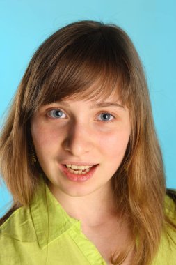 Mavi stüdyo arka planda poz yeşil giysiler içinde Güzellik genç model