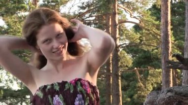 Deniz kıyısında poz veren uzun saçlı güzel bir kadın.