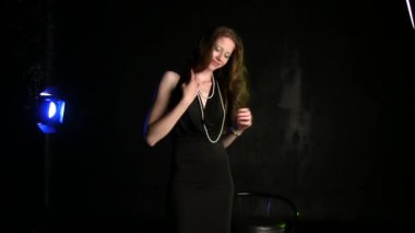 Siyah stüdyo geçmişinde poz veren güzel genç bir kadın.