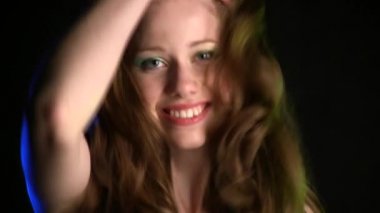 Siyah stüdyo geçmişinde poz veren güzel genç bir kadın.