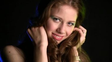 Siyah stüdyo geçmişinde poz veren güzel genç bir kadın.