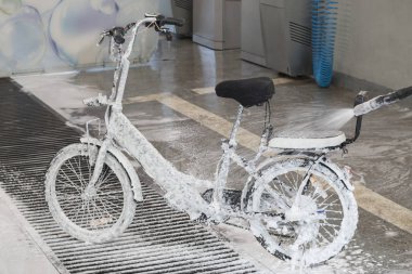 Bir elektrikli bisiklet bir jet köpük ile bir oto yıkama yıkama
