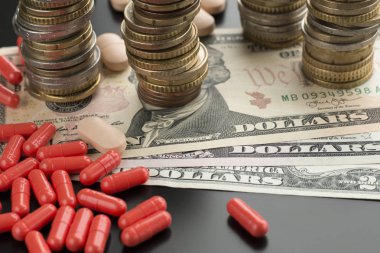 Kırmızı hapları veya kapsül ve doları banknot ve arka demir yığınları. Sağlık giderleri kavramı