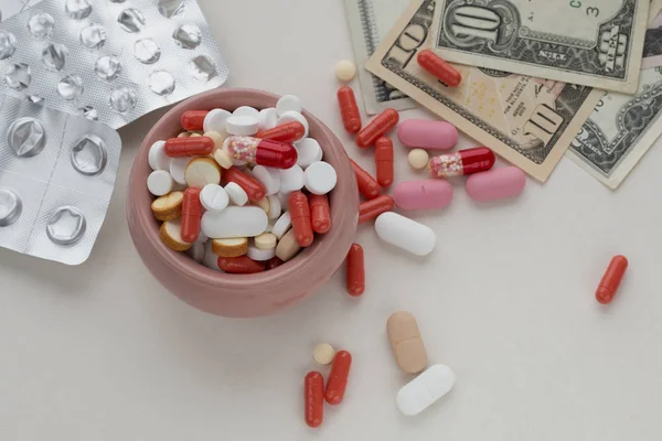 Assorted Pharmaceutical Pills Bowl Empty Blister Packs Dollar Bills Light — Stock Photo, Image