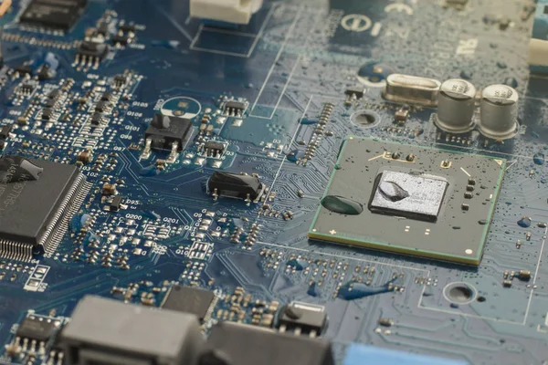 Part of the electrical circuit motherboard covered with water droplets. Close up image, selective focus