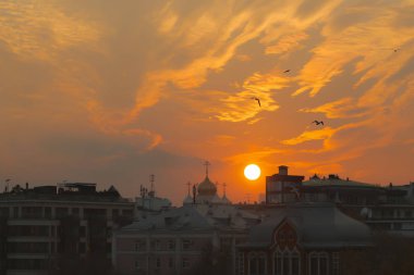 İnanılmaz etkileyici doğa günbatımı ışık kırmızı, turuncu ve sarı tonlarında. Şehir silüeti üzerinde turuncu kırmızı günbatımı