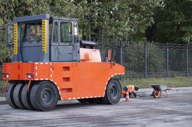 Ağır makine el ile emek ve el araçları karşı. Silindir Kompaktör makine yeni asfalt basmak için. Çalışma, yol yapım yenileme işlemi