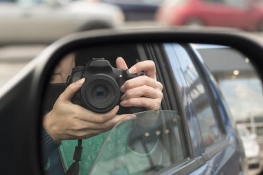 Gizli çekim. Kadının kamera ile araba aynada yansıması. Paparazzi kavramı