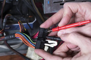Bir adam elektrik güç kaynağı test eder. Kişisel bilgisayar onarım işlemi. Teknisyen ekipmanları tamir.