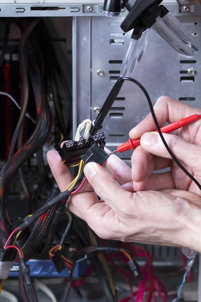 Technician is testing the electrical power of power supply. Technician equipment repair. Personal computer repair process.