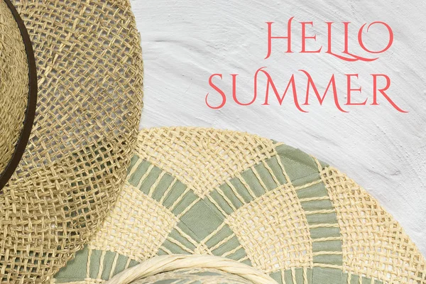 Straw hats, Hello summer text on white limed background, copy space. Summer concept, welcome summer season