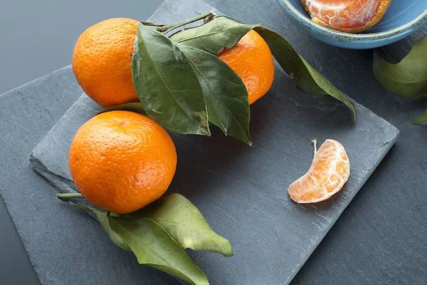 Oranžové Mandarinky Listy Pozadí Černé Břidlicové Desky Selektivní Zaměření — Stock fotografie