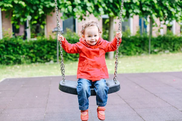 Ragazzina Trench Rosso Parco Giochi Bambino Altalena — Foto Stock