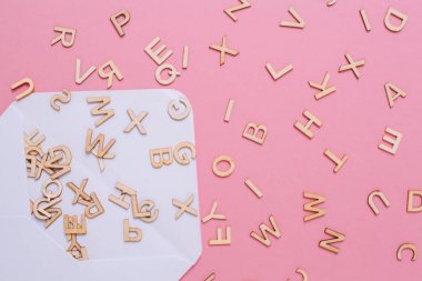 Pembe arka plan üzerinde birçok abc harfleri ile açılan beyaz zarf.