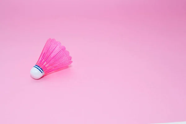 Pink badminton shuttlecock isolated on the pink background.