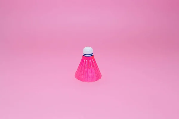Pink badminton shuttlecock isolated on the pink background.