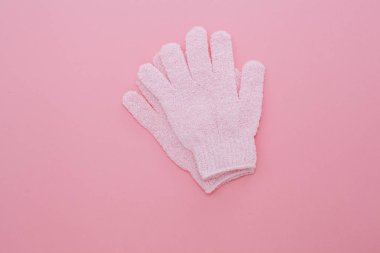 Kadın pembe arka plan üzerinde duş için masaj eldivenpeeling.
