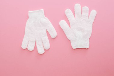 Kadın pembe arka plan üzerinde duş için masaj eldivenpeeling.