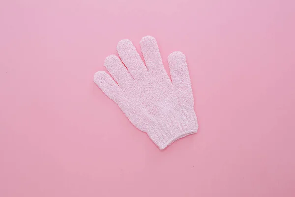 Woman exfoliating massage glove for shower on pink background. — Stockfoto