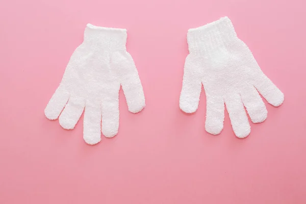 Woman exfoliating massage glove for shower on pink background. — Stockfoto