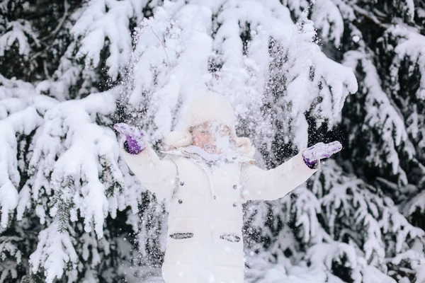 Portrait de petite fille en hiver. Tout-petit jouant avec la neige dans — Photo