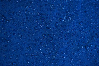 Görünüm doku mavi sentetik su geçirmez giyim. Su geçirmez naylon üzerine su damlaları. Suya dayanıklı tekstile yağmur damlaları. Yağmur damlası ile su geçirmez kaplama arka plan. Yağmur damlaları ile yağmur geçirmez çadır.