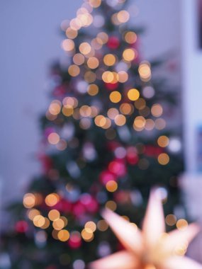 Deodaklanmış ışıklar ve yıldız ile Noel ağacı. Noel soyut bulanıklık arka plan. Noel ağacı ile odak tatil arka plan dışında. Xmas ağacından hafif bokeh. Xmas ve Yeni Yıl teması.