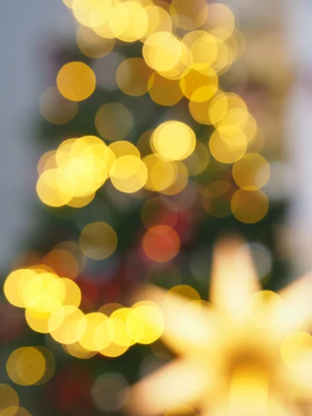 Christmas tree with defocused lights and star. Christmas abstract blur background. Out of focus holiday background with christmas tree. Light bokeh from Xmas tree. Xmas and New Year theme.