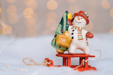 Üzerinde kırmızı tahta Noel Baba 'nın kızağı olan bir Noel kartı ve bulanık arka planda Xmas ağacı topları. Xmas ve Yeni Yıl teması. Kopya alanı ile Noel ve Yeni Yıl kavramı.