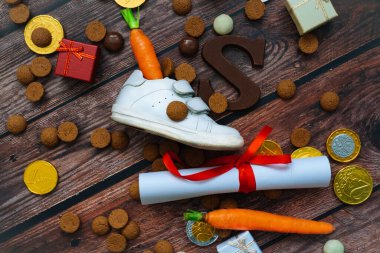 Çocuk nalı, Noel Baba 'nın atı için havuç, hediyeler, geleneksel tatlı pepernoten ve çikolata mektuplu Hollanda bayramı Sinterklaas arka planı. Schoentje zetten konsepti. Kopyalama alanı olan düz.