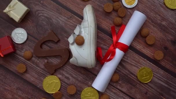 Holandská dovolená Sinterklaas pozadí. Dětská obuv, mrkev pro Santova koně, dárky, tradiční sladkosti pernoten a čokoládový dopis. Schoentje zetten koncept. Video 4k